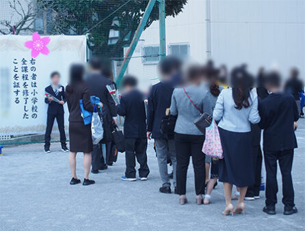 スタッフがお伺いした板橋区某小学校では、卒業証書 背景幕前での写真撮影の為に、卒業証書幕の前には長い列が出来上がっています。